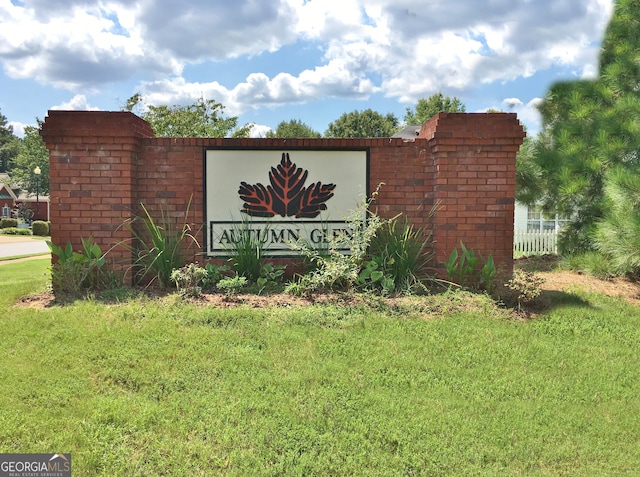 community / neighborhood sign featuring a lawn