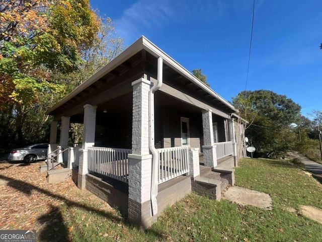 view of side of home featuring covered porch