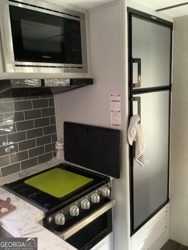 kitchen featuring decorative backsplash and stainless steel microwave