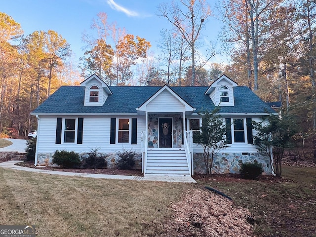 cape cod house with covered porch and a front yard