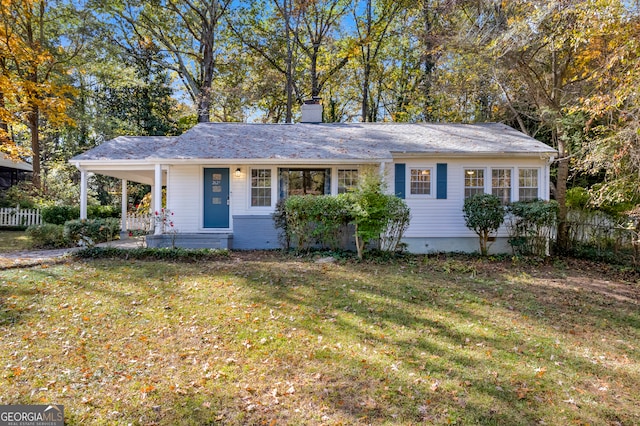 ranch-style home featuring covered porch and a front lawn