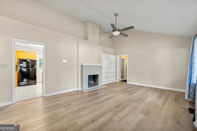 unfurnished living room with a brick fireplace, built in shelves, ceiling fan, high vaulted ceiling, and light hardwood / wood-style floors