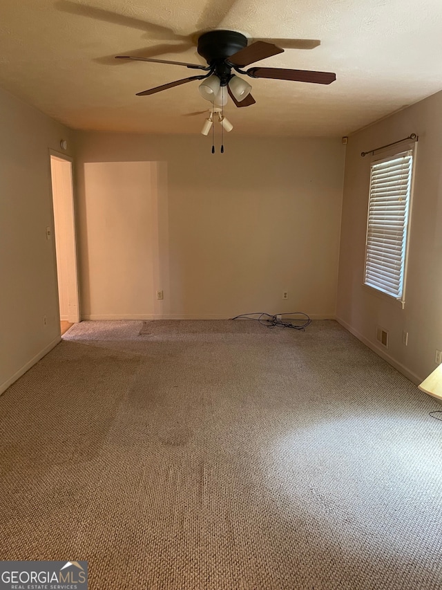 carpeted spare room featuring ceiling fan