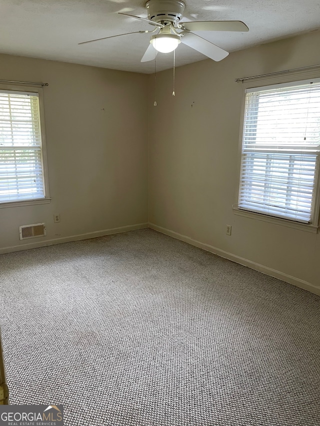 empty room featuring carpet flooring, plenty of natural light, and ceiling fan