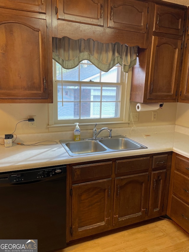 kitchen featuring sink, light wood-type flooring, and black dishwasher