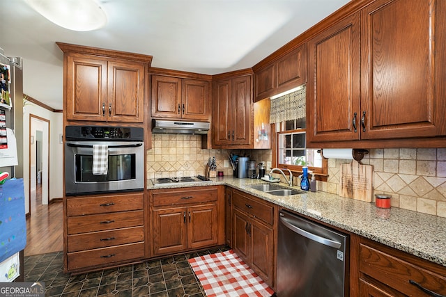 kitchen featuring sink, stainless steel appliances, tasteful backsplash, light stone counters, and dark hardwood / wood-style floors