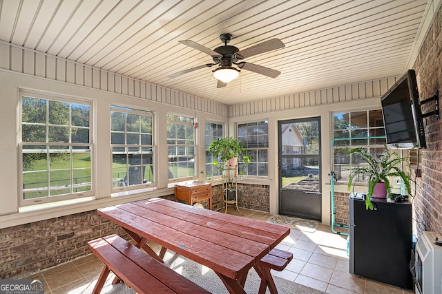 sunroom / solarium featuring ceiling fan, a healthy amount of sunlight, and wood ceiling