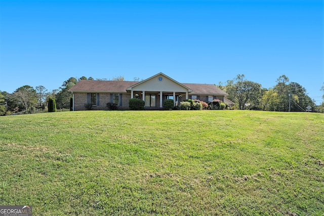 ranch-style home featuring a porch and a front yard