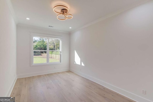 empty room with light wood-type flooring and crown molding