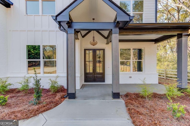 view of exterior entry with a porch and french doors