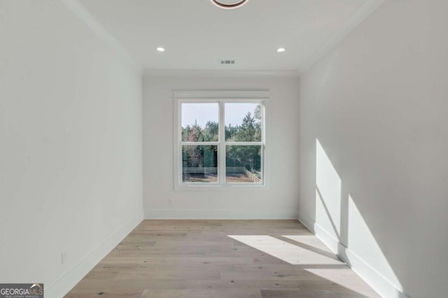 empty room featuring crown molding and light wood-type flooring