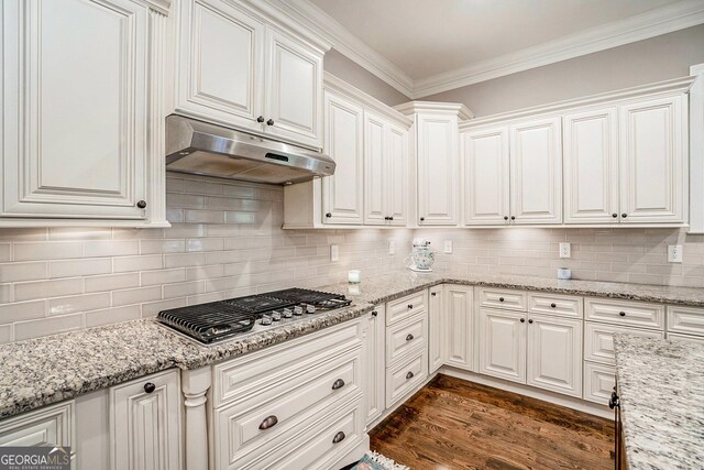 kitchen featuring stainless steel gas stovetop, dark hardwood / wood-style flooring, white cabinetry, and decorative backsplash