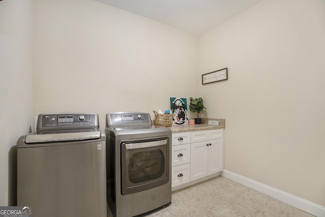 laundry room featuring independent washer and dryer, cabinet space, and baseboards