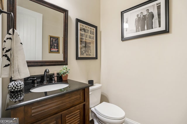 half bathroom with toilet and vanity