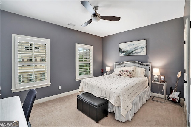 bedroom featuring a ceiling fan, light colored carpet, visible vents, and baseboards