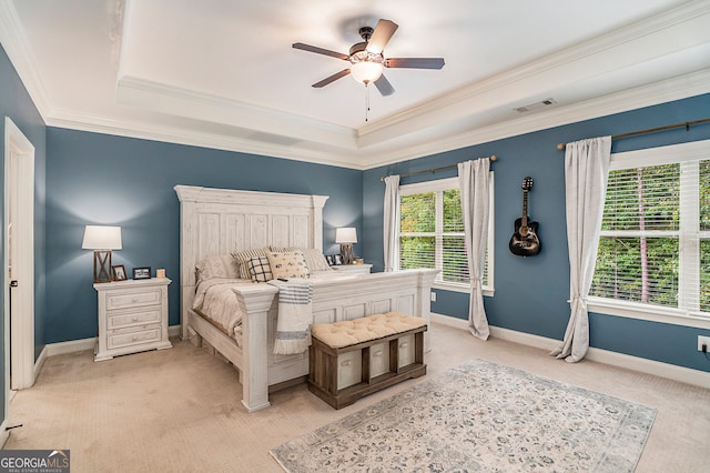 bedroom featuring a raised ceiling, ceiling fan, light colored carpet, and ornamental molding