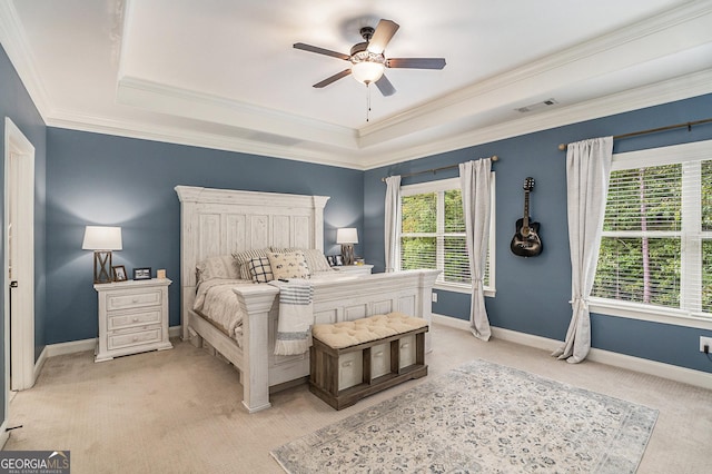 bedroom featuring light colored carpet, visible vents, baseboards, ornamental molding, and a raised ceiling