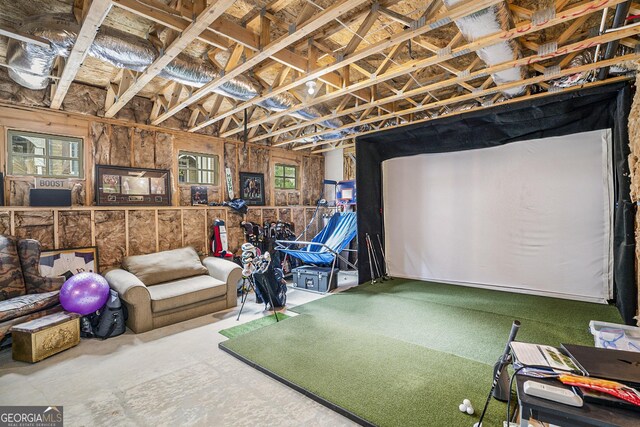 recreation room featuring concrete floors and golf simulator