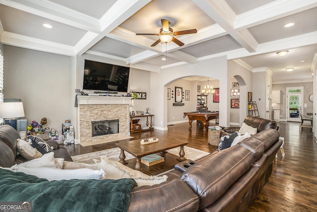 living room with arched walkways, coffered ceiling, dark wood-style flooring, beamed ceiling, and a fireplace