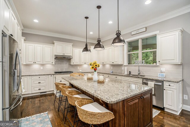 kitchen with pendant lighting, a center island, dark hardwood / wood-style floors, white cabinetry, and stainless steel appliances