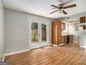 unfurnished living room featuring french doors, light hardwood / wood-style flooring, and ceiling fan