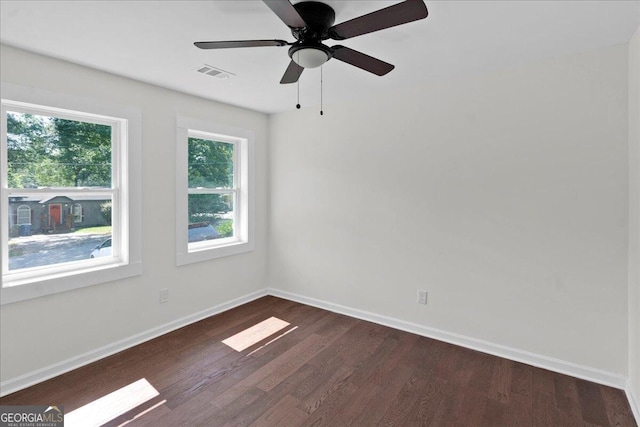 spare room with dark hardwood / wood-style flooring and ceiling fan