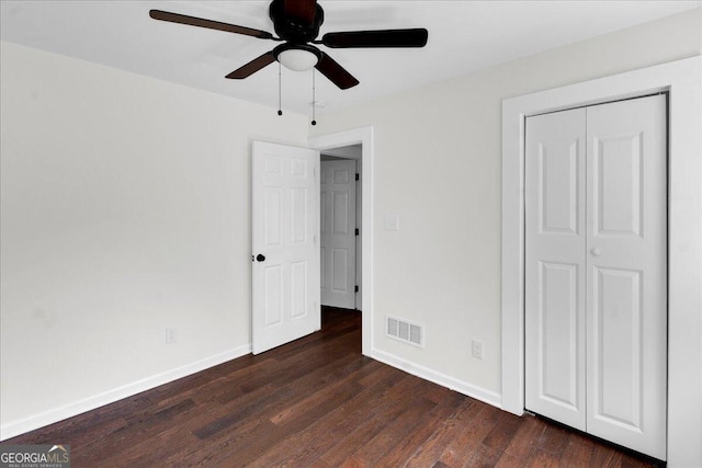 unfurnished bedroom with a closet, ceiling fan, and dark hardwood / wood-style flooring