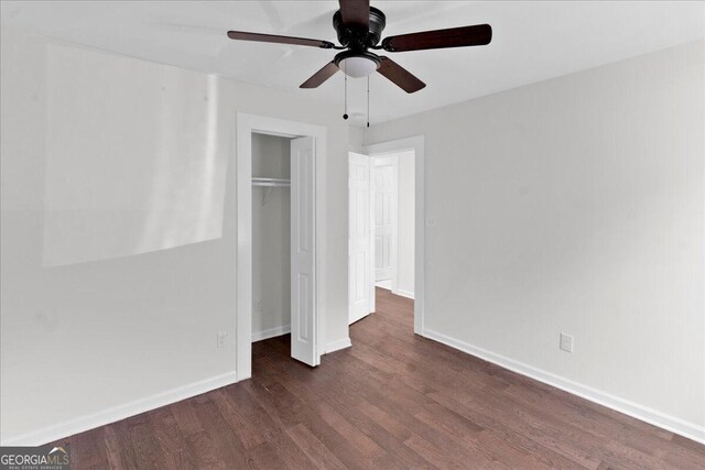 unfurnished bedroom featuring ceiling fan, dark wood-type flooring, and a closet