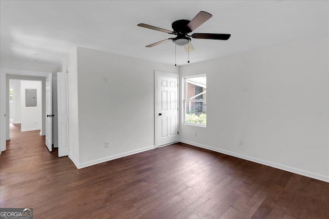 spare room with electric panel, ceiling fan, and dark hardwood / wood-style floors