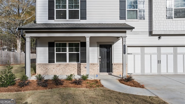 doorway to property featuring covered porch and a garage