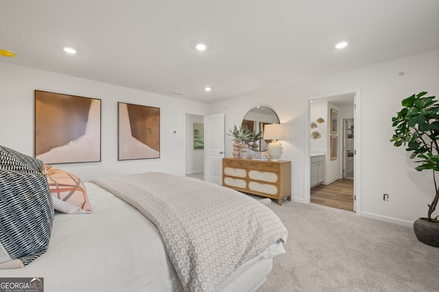 bedroom with light colored carpet and ensuite bath