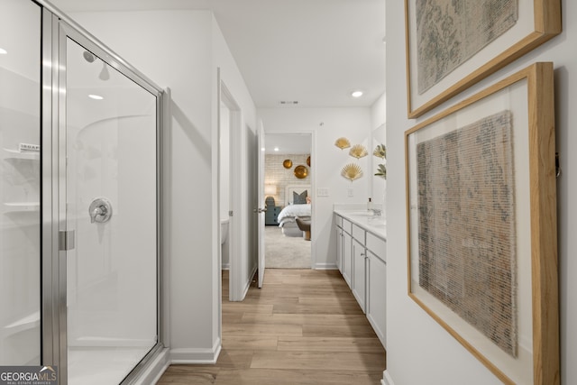 bathroom with hardwood / wood-style floors, vanity, toilet, and a shower with shower door