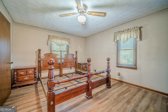 bedroom featuring hardwood / wood-style floors, ceiling fan, and a textured ceiling