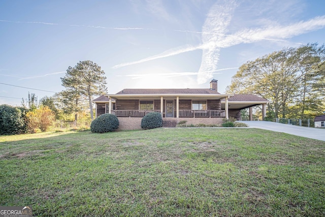 view of front facade with a front lawn, covered porch, and a carport