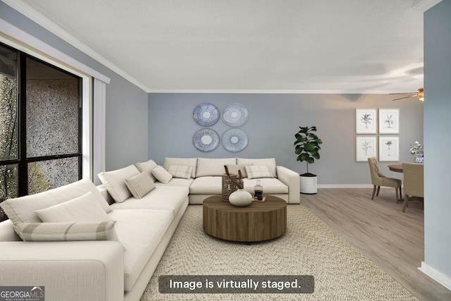 living room featuring ceiling fan, wood-type flooring, and ornamental molding