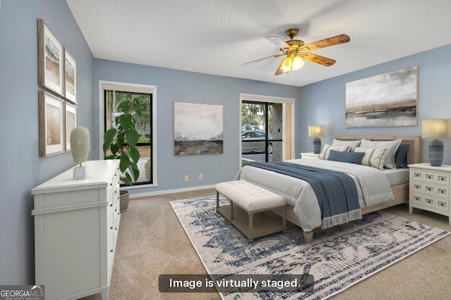 carpeted bedroom with ceiling fan and a textured ceiling