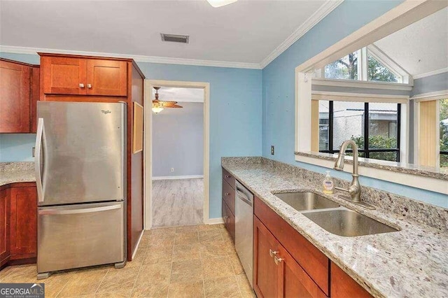 kitchen featuring light stone countertops, sink, ornamental molding, and appliances with stainless steel finishes