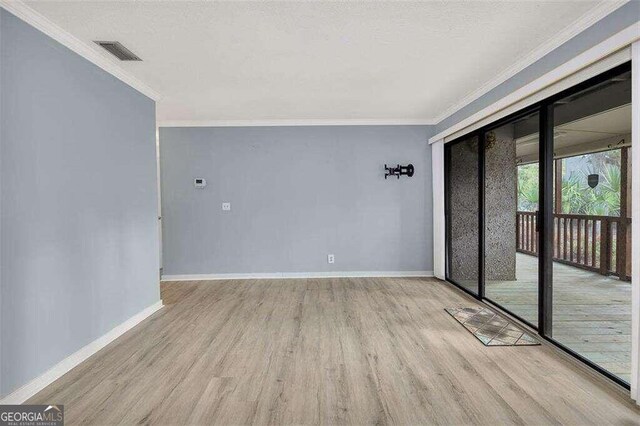 spare room with crown molding and light hardwood / wood-style flooring