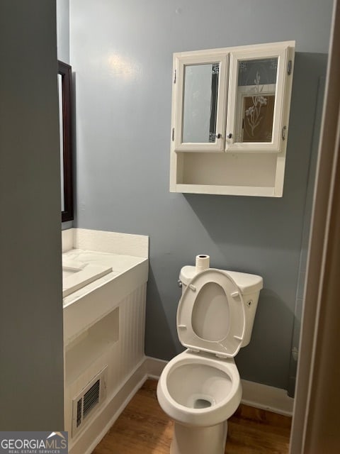 bathroom featuring hardwood / wood-style floors and toilet