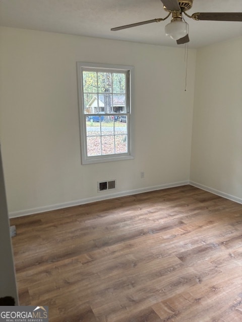 empty room with hardwood / wood-style flooring and ceiling fan