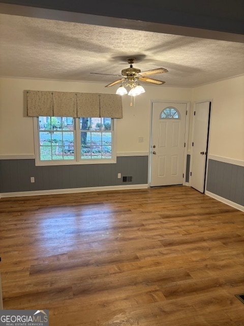 foyer entrance featuring wood-type flooring, a textured ceiling, and ceiling fan