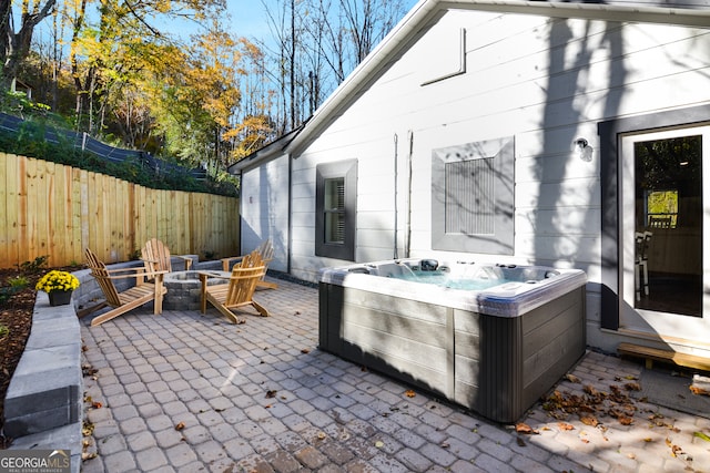 view of patio featuring a hot tub and a fire pit