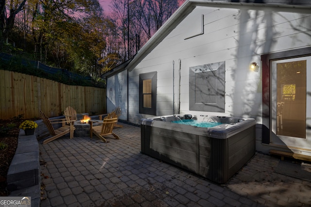 patio terrace at dusk with a hot tub and a fire pit