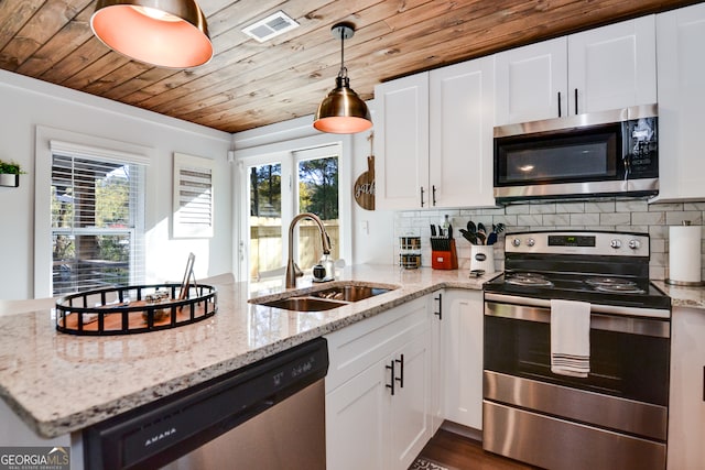 kitchen featuring white cabinetry, sink, light stone counters, and appliances with stainless steel finishes