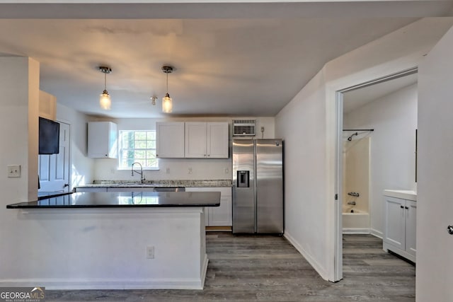 kitchen featuring stainless steel fridge with ice dispenser, dark wood-type flooring, white cabinets, and pendant lighting