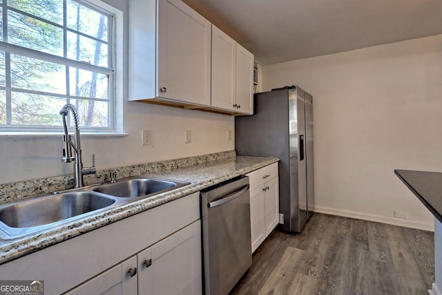 kitchen featuring stainless steel appliances, white cabinetry, and a healthy amount of sunlight