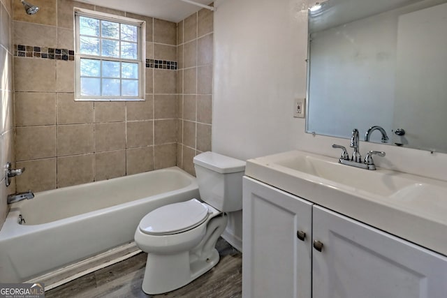 full bathroom featuring hardwood / wood-style floors, vanity, toilet, and tiled shower / bath