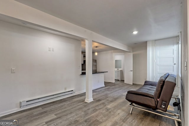 living area with hardwood / wood-style floors and baseboard heating