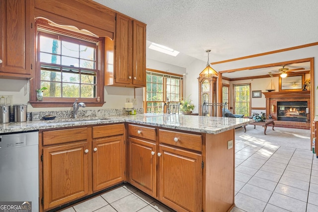 kitchen featuring sink, stainless steel dishwasher, light stone counters, and kitchen peninsula