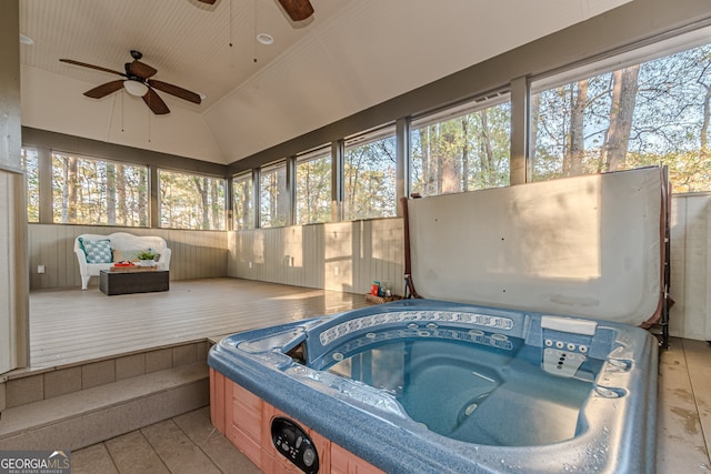 sunroom / solarium with ceiling fan, a healthy amount of sunlight, a jacuzzi, and vaulted ceiling